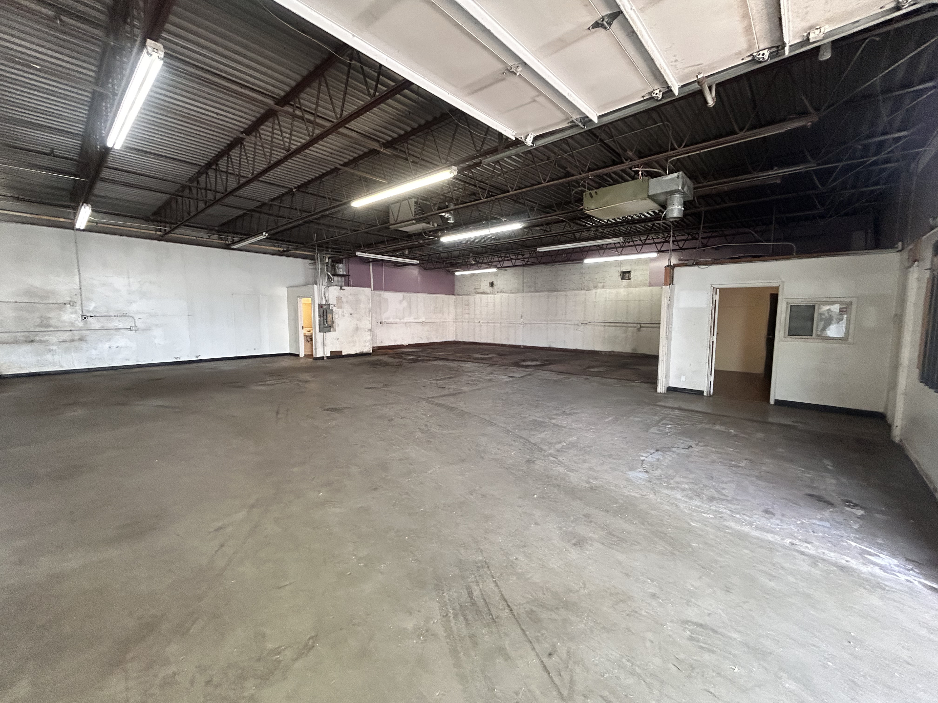 Interior warehouse space with open floor and overhead lighting